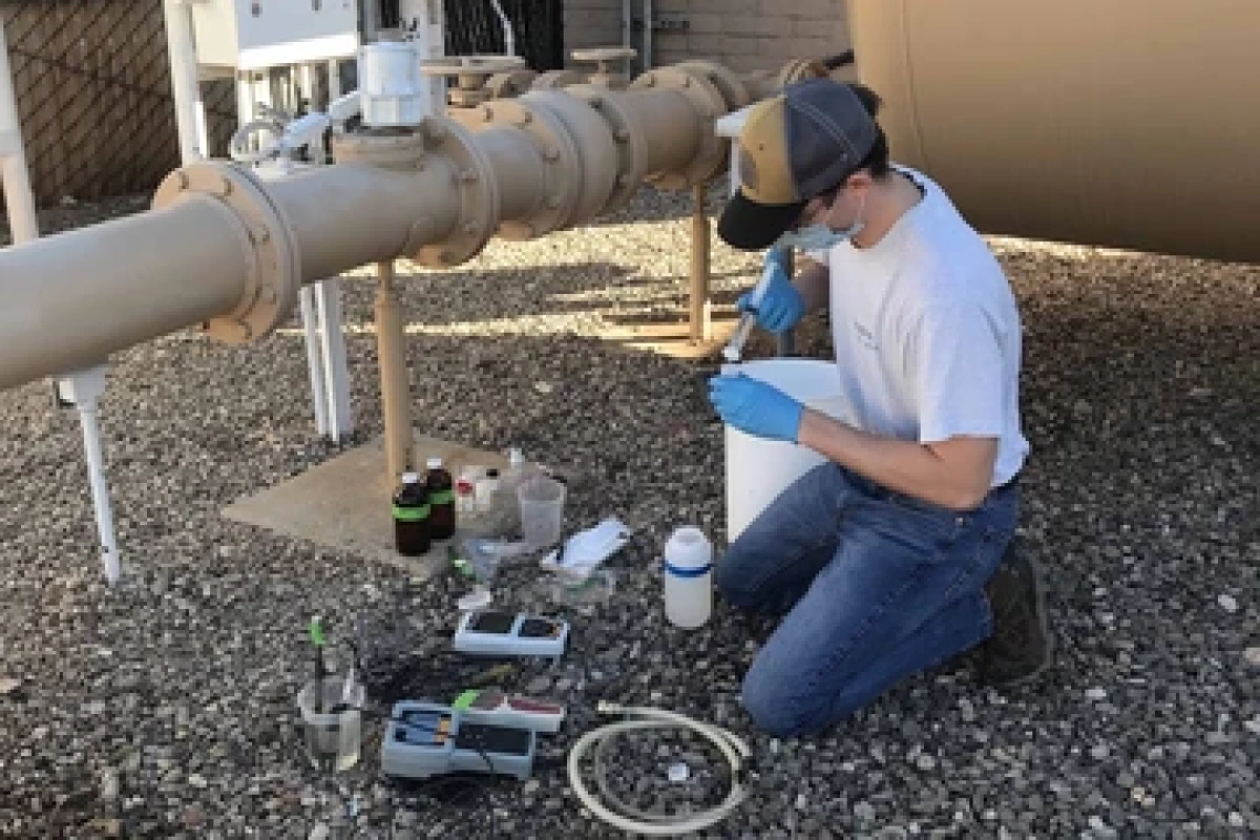 Chandler Noyes Collecting Well Water Sample Inline